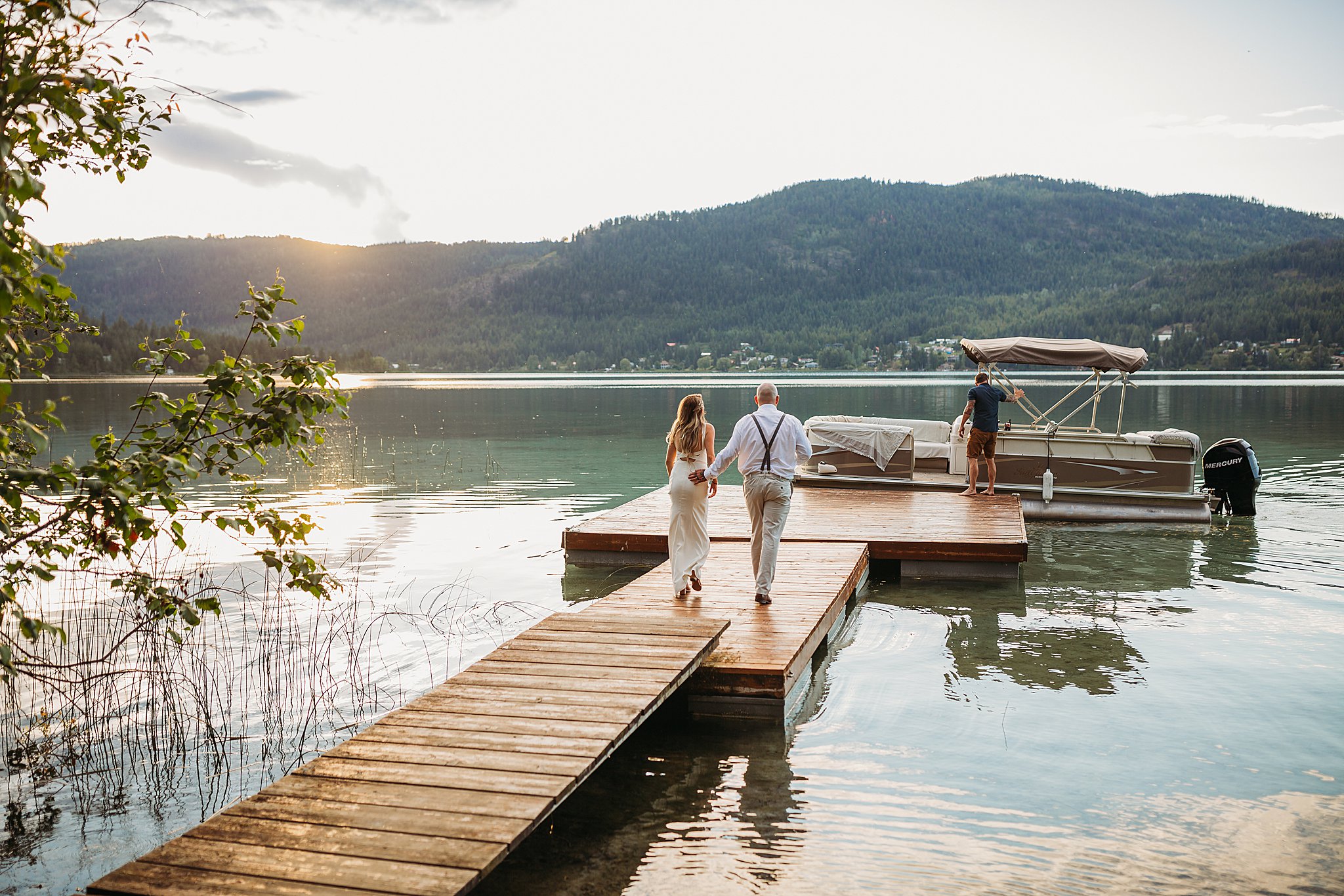 bride and groom on a dock at sunset leaving for an evening boat ride at white lake cabins