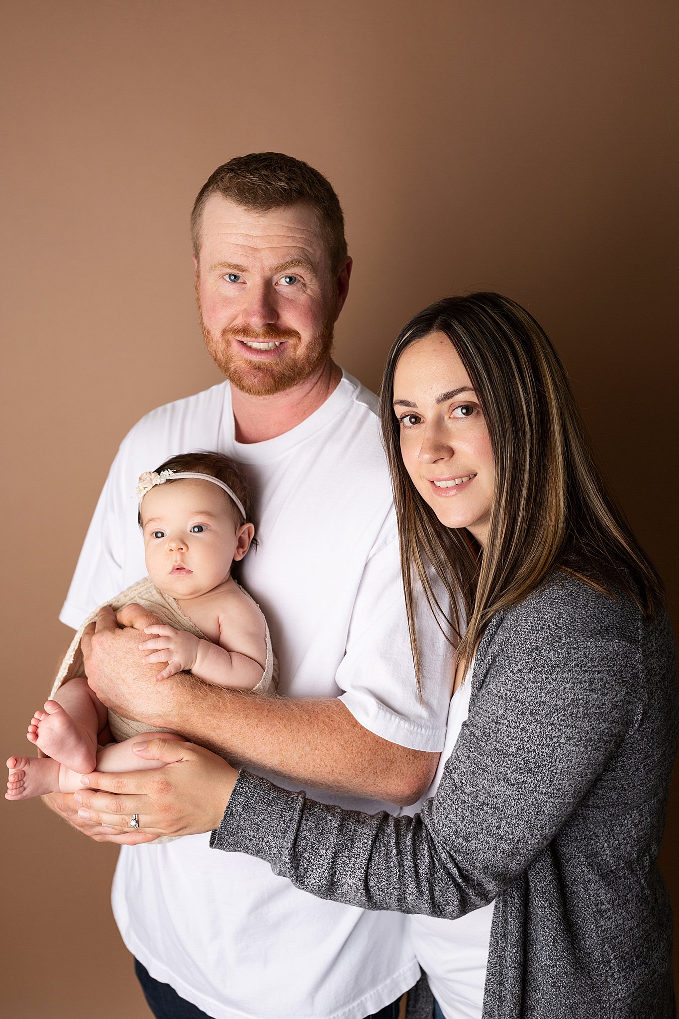 Newborn studio photography parent posing with mom and dad.